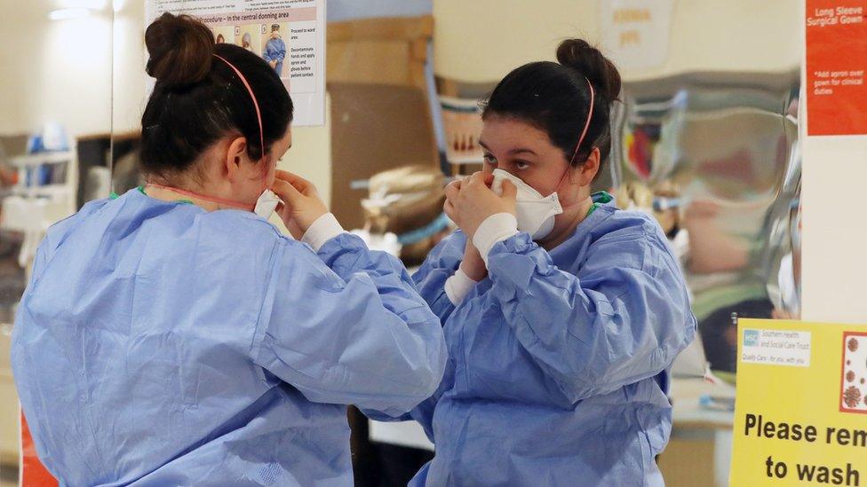 Medic putting on PPE at Craigavon Area Hospital in Northern Ireland