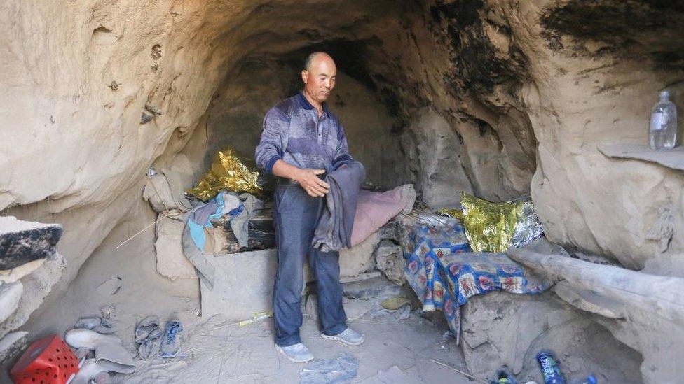 This photo taken on May 24, 2021 shows shepherd Zhu Keming, hailed as a hero in China for rescuing six ultramarathon runners when extreme weather hit the area leaving at least 20 dead, showing the cave dwelling where he sheltered the stricken athletes near the city of Baiyin, in China's northwestern Gansu province.