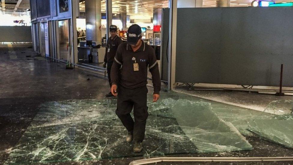 Staff clear up after the gun and bomb attack at Istanbul airport, 29 June