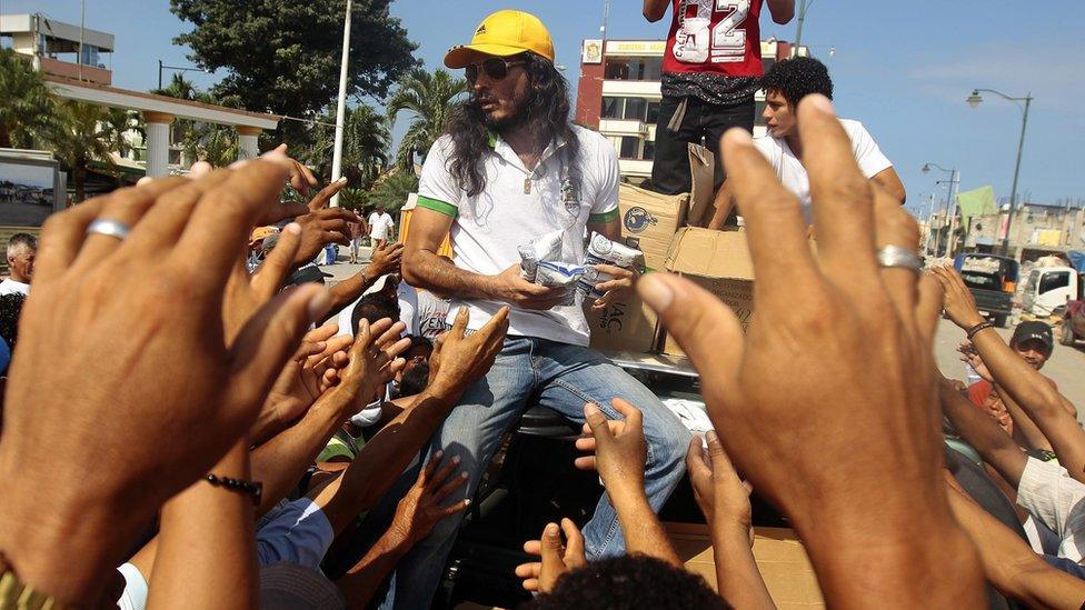 A man delivers aid to people affected by the earthquake in Pedernales, Ecuador, on 19 April 2016