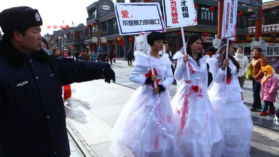 Li Tingting in the middle and two others wear paint-spattered wedding dresses