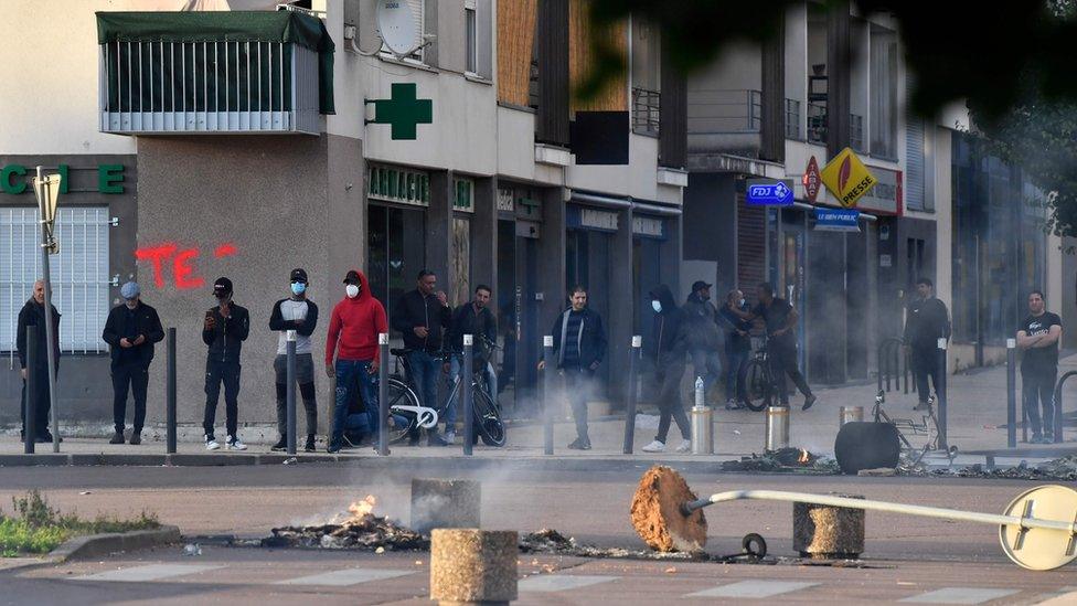 People stand on a damaged street in Dijon on Monday