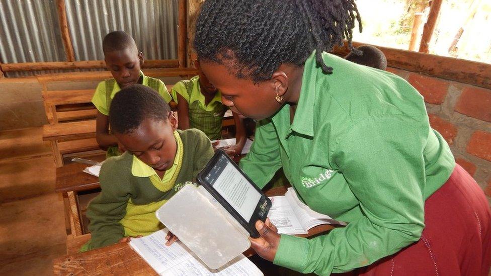 A teacher interacts with a student at a Bridge International school in Uganda
