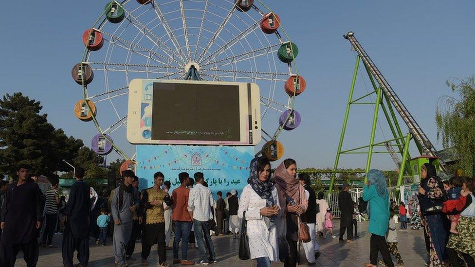 Afghan visitors walk through the Park Shahar or City Park, in Kabul on September 6, 2017.