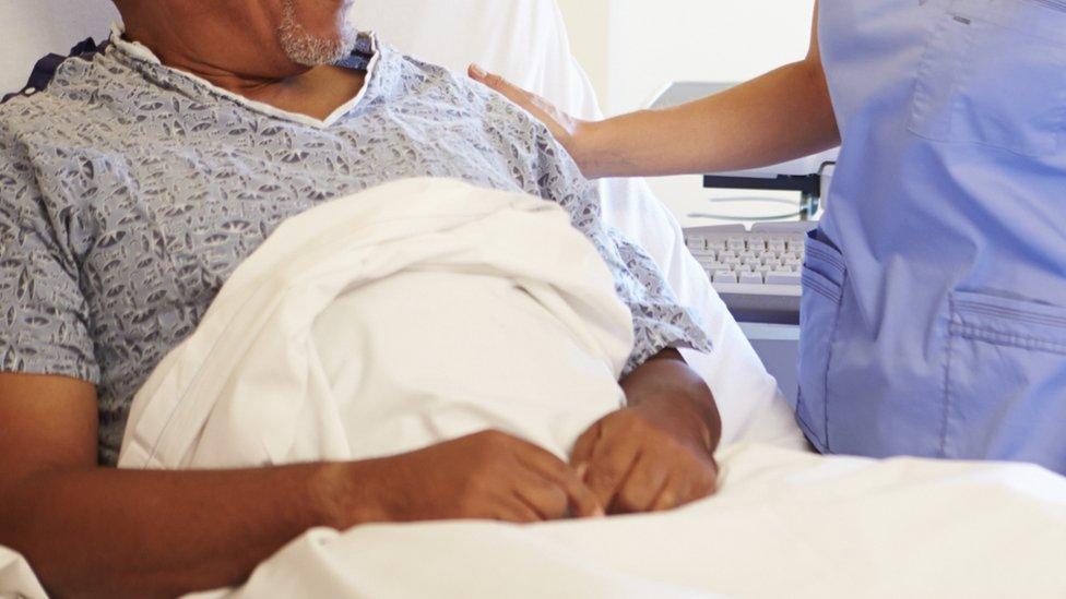 Patient in hospital bed and nurse