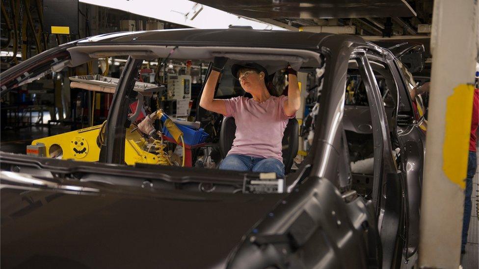 Engineer working on car at car plant