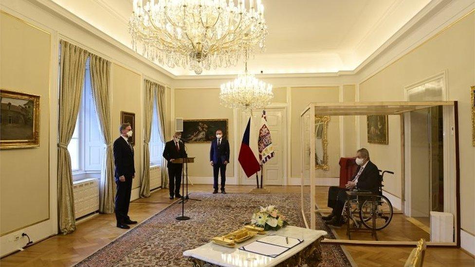 Czech President Milos Zeman, separated by a transparent wall after testing positive for the coronavirus , appoints Civic Democratic Party (ODS) leader Petr Fiala as the new prime minister.