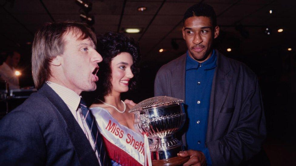 A woman is presented with a trophy