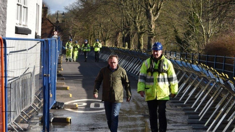 Environment Secretary George Eustice is accompanied by a member of the Environment Agency