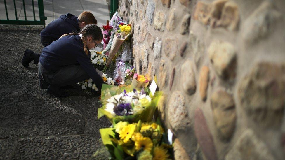 Children lay flowers in remembrance of the Aberfan disaster