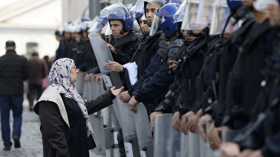 Nissa Imad confronting a line of riot police in Algeria