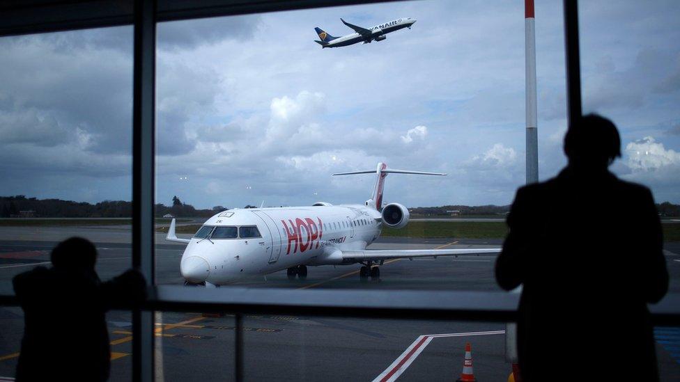 Passengers are seen in silhouette as at Nantes airport