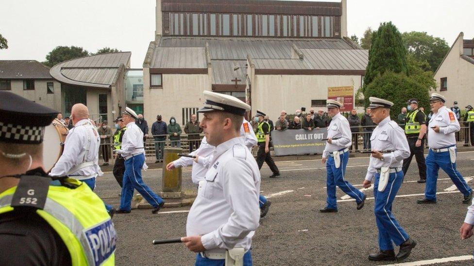 Orange Walk passing Catholic church