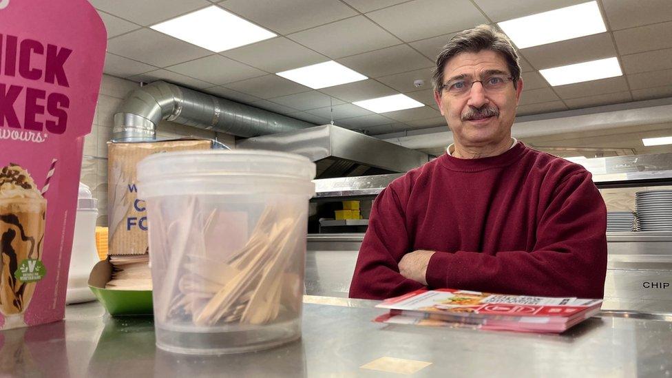 Fish and chip shop owner standing behind a counter