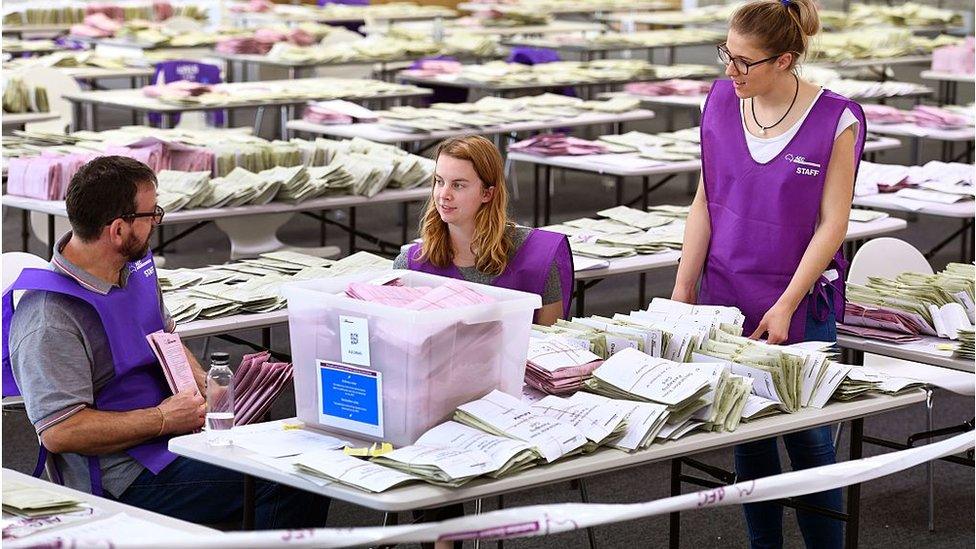 Officials with ballots at a polling booth