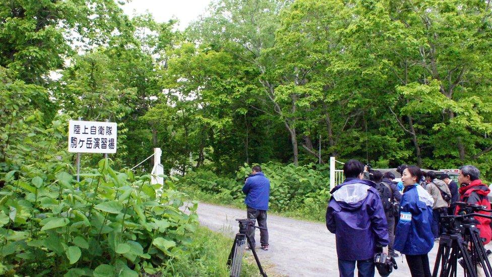 Media members gather near a military drill area in Shikabe town, on the northernmost main island of Hokkaido Friday, 3 June 2016.