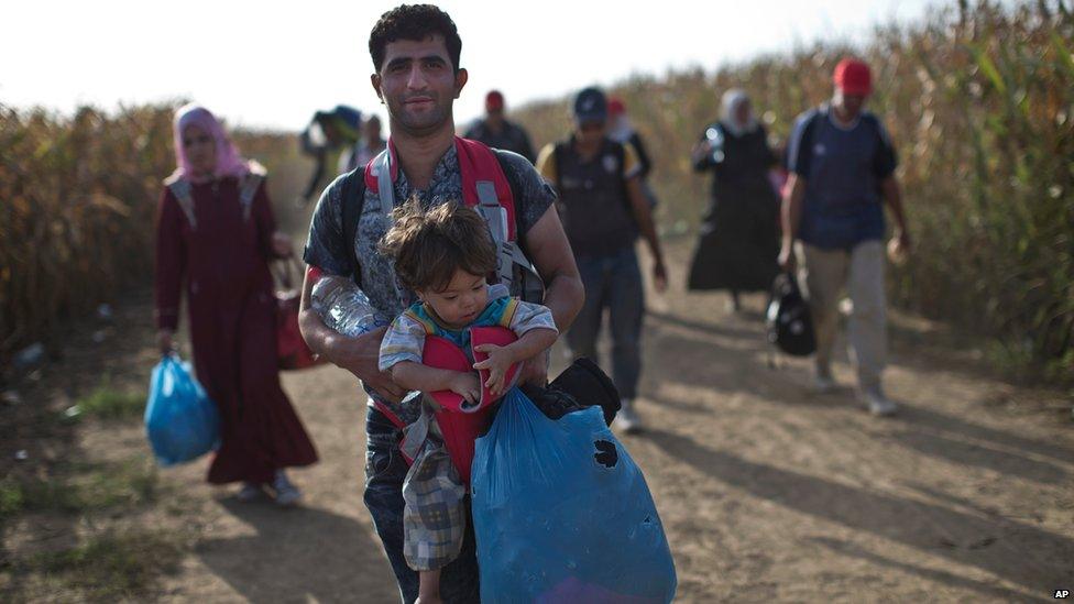 People walk through fields towards Croatia near the Serbian town of Sid - 19 September