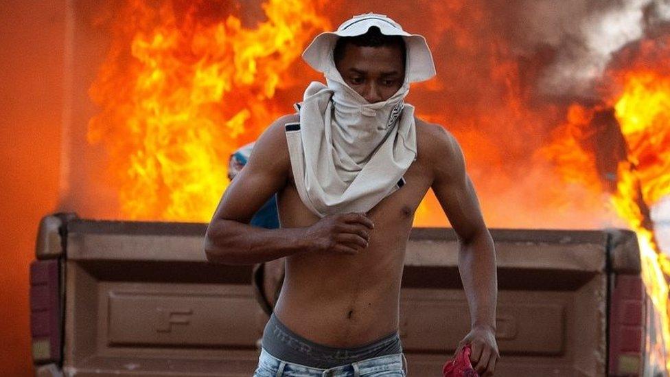 A person runs during clashes between opponents of Venezuelan President Nicolas Maduro and members of the Bolivarian National Guard of Venezuela