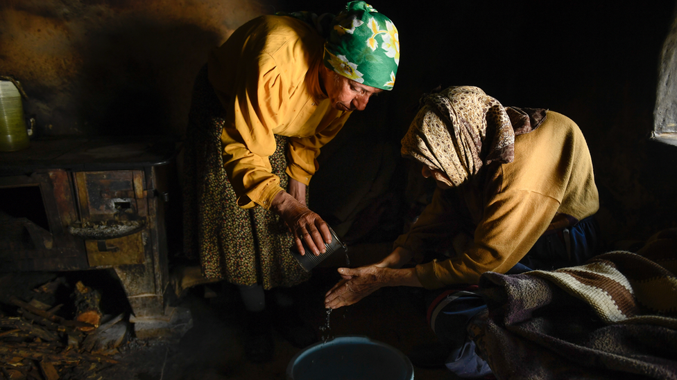 Hatidze is helping her mother Nazife to wash hands