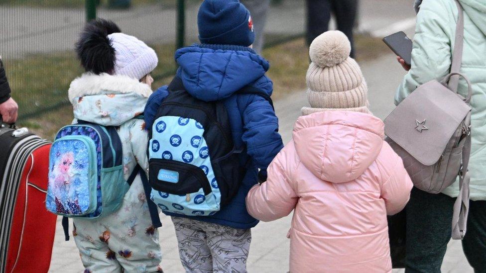 Three children arriving at a border