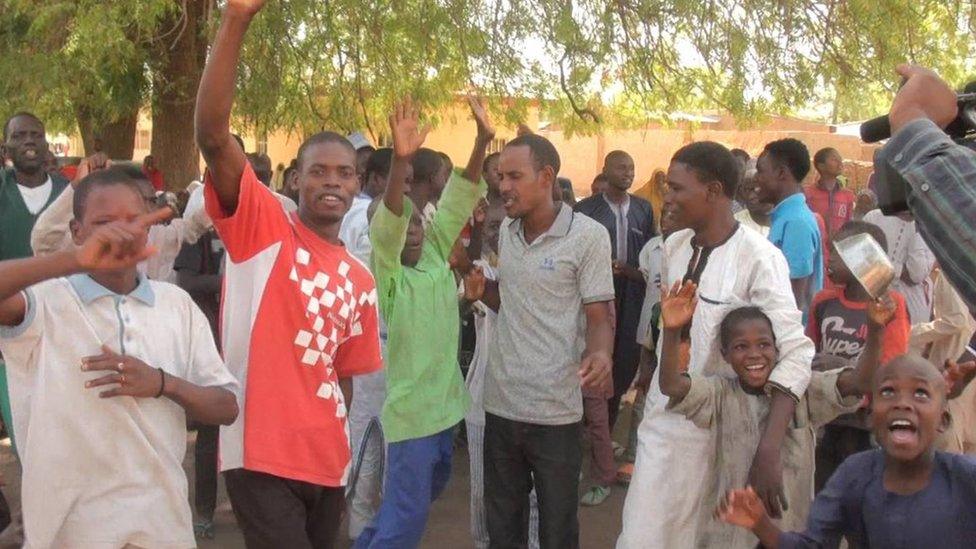 People waving their arms in joy in Dapchi