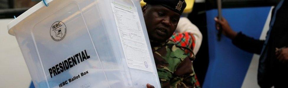 A security policeman unloads sealed ballot boxes from a bus to the Jamuhuri High School tallying center in Nairobi