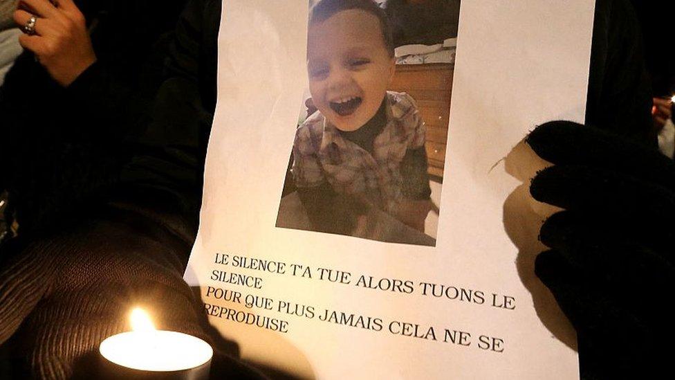 A woman holds a placard bearing a portrait of Tony, a child who died on November 26, 2016 at the age of three