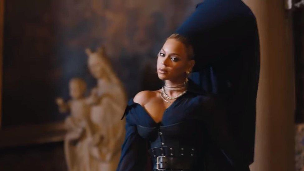 Beyonce in a black robe and large Pope-like hat