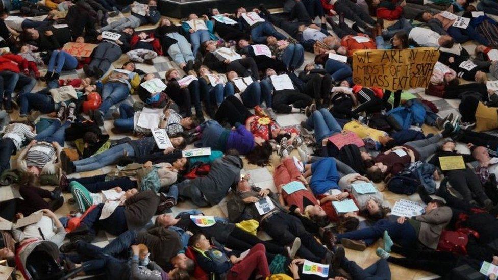 Handout photo issued by Extinction Rebellion Scotland of protesters from the Wee Rebellion staging a "die in" beneath Dippy the Dinosaur at Kelvingrove Art Gallery and Museum in Glasgow