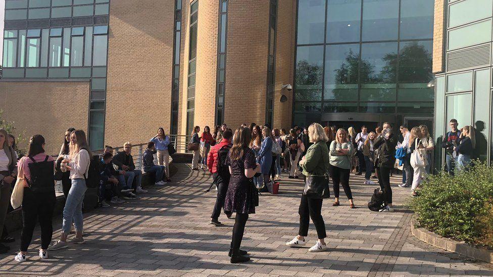 Students gather outside the Ulster University campus in Derry