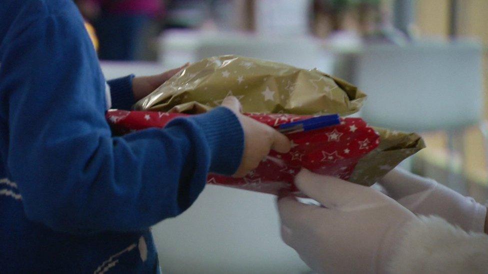 Boy accepts gift from Santa