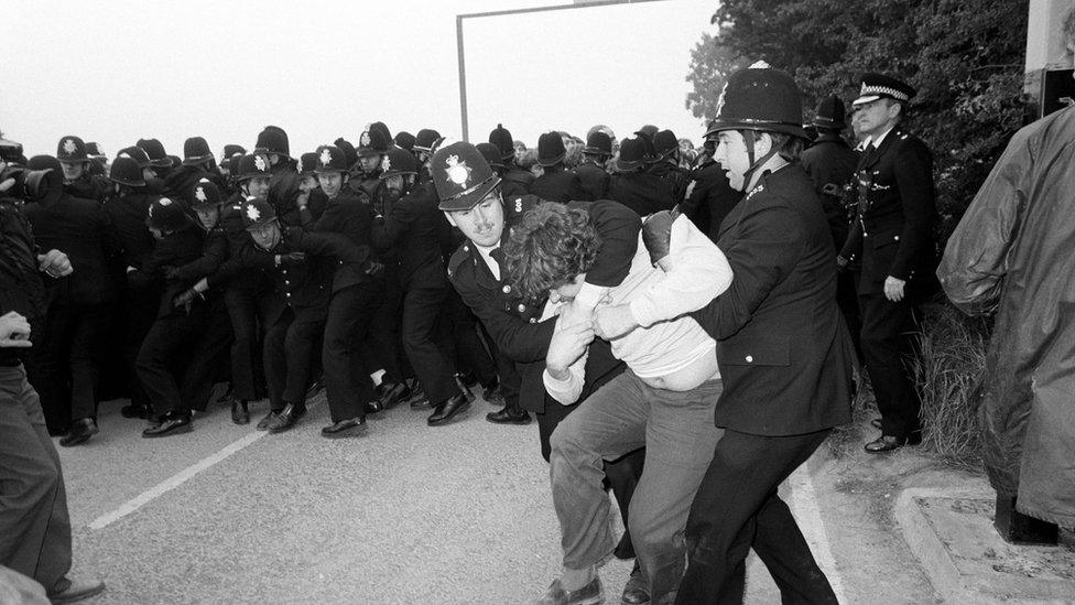 Police grapple with a picket as police lines other pickets back at Gascoigne Wood drift mine near Selby