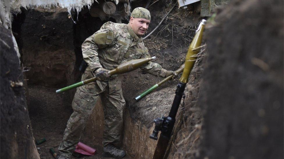 A Ukrainian soldier carrying rocket-propelled grenades in Ukraine's Luhansk region