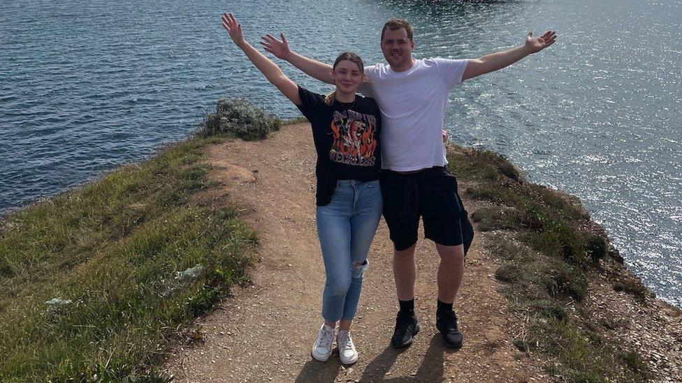 Ben Robinson and his fiancé, Kelly White, standing on a path overlooking the sea