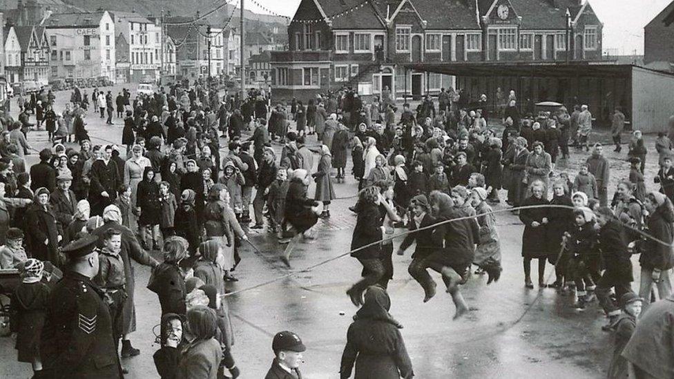 Black and white photo of people skipping in a big crowd