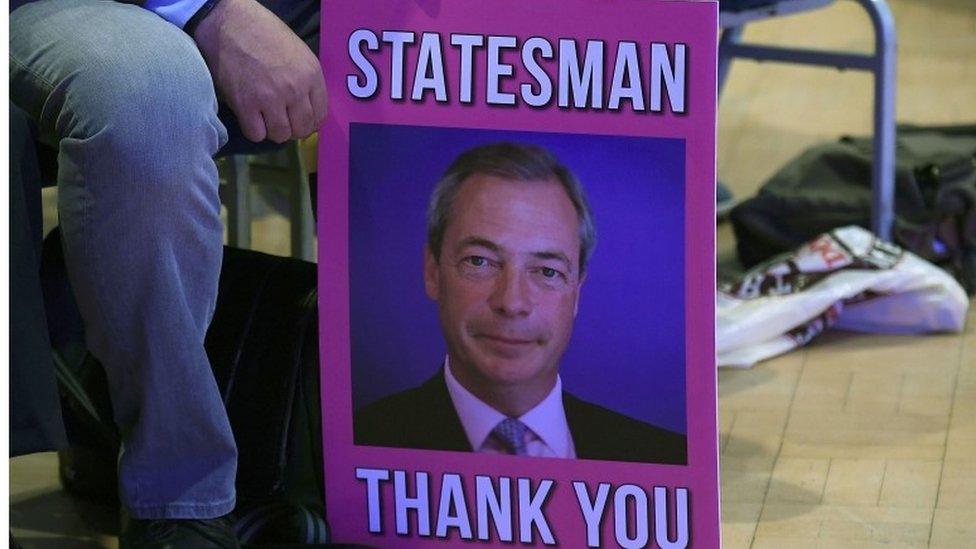 Man holding Nigel Farage placard