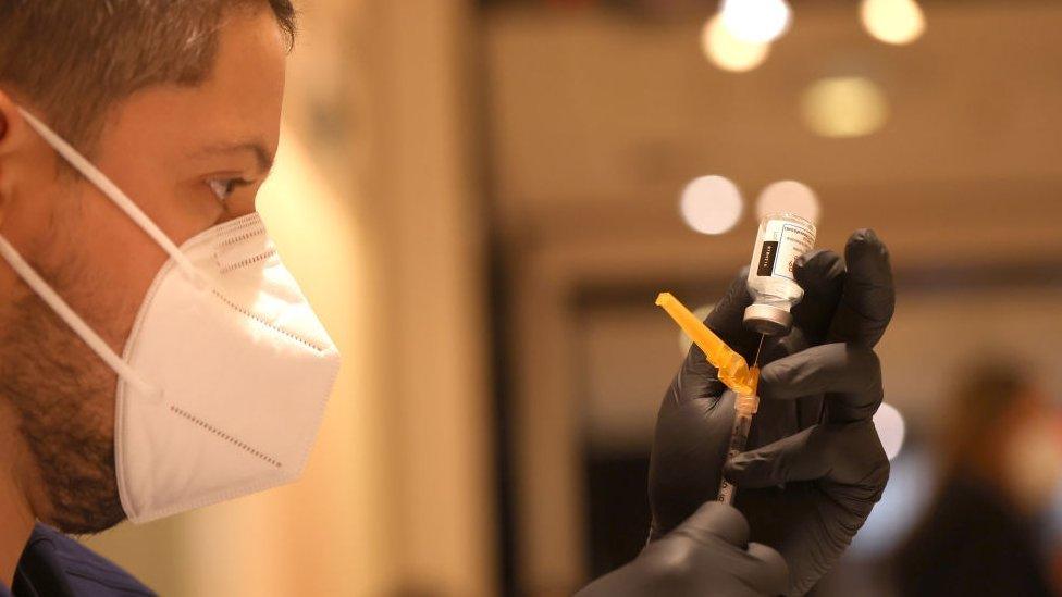 A medical worker fills a syringe with a Covid vaccine