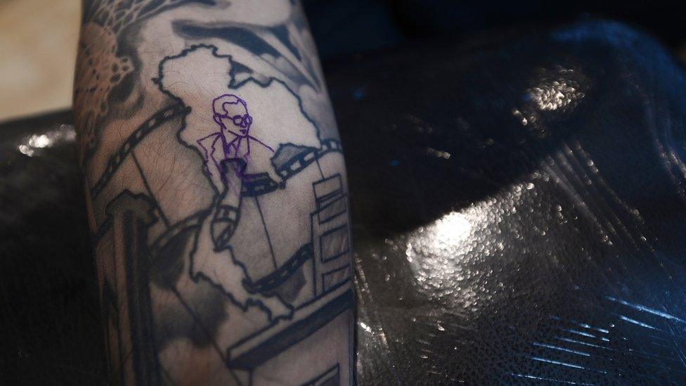 Tattoo showing King Bhumibol within a map of Thailand