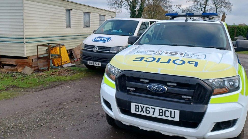 Police and RSPCA vehicles at a mobile home