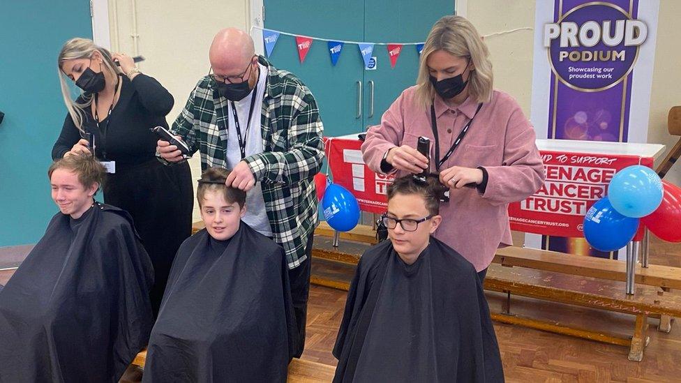 Local hairdressers shave the boys' heads