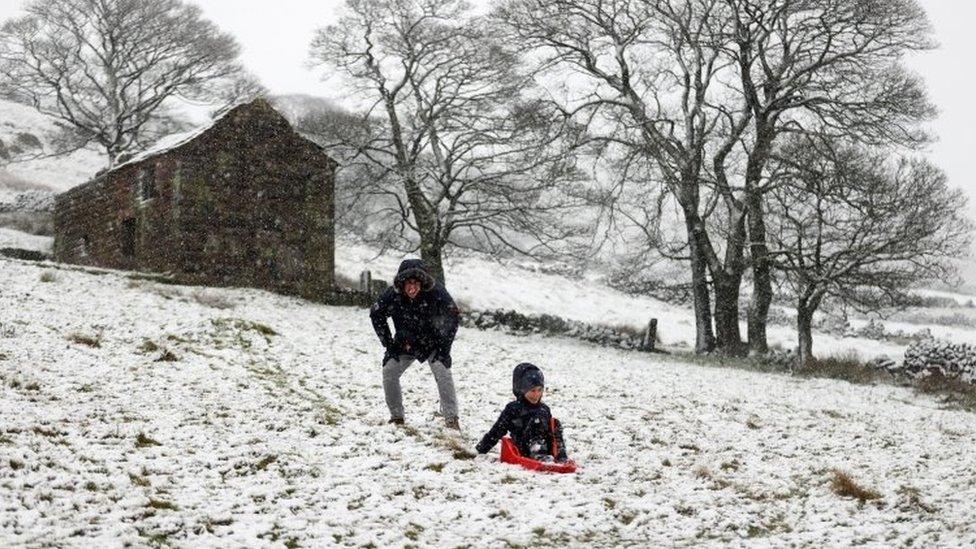 People play in the snow in The Roaches ridge, Staffordshire