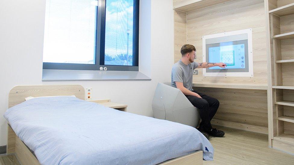 Man touching an electronic screen in a bedroom