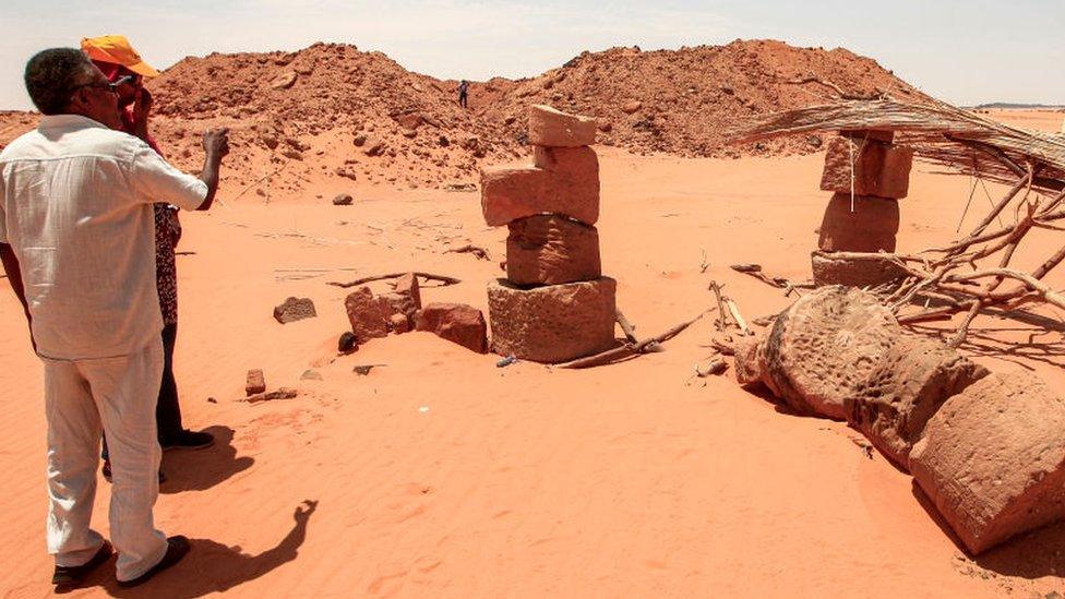 Mahmoud al-Tayeb, a former expert from Sudan's antiquities department, inspects stones stacked up on top of each other to prop up a roof for a dining room to be used by gold hunters