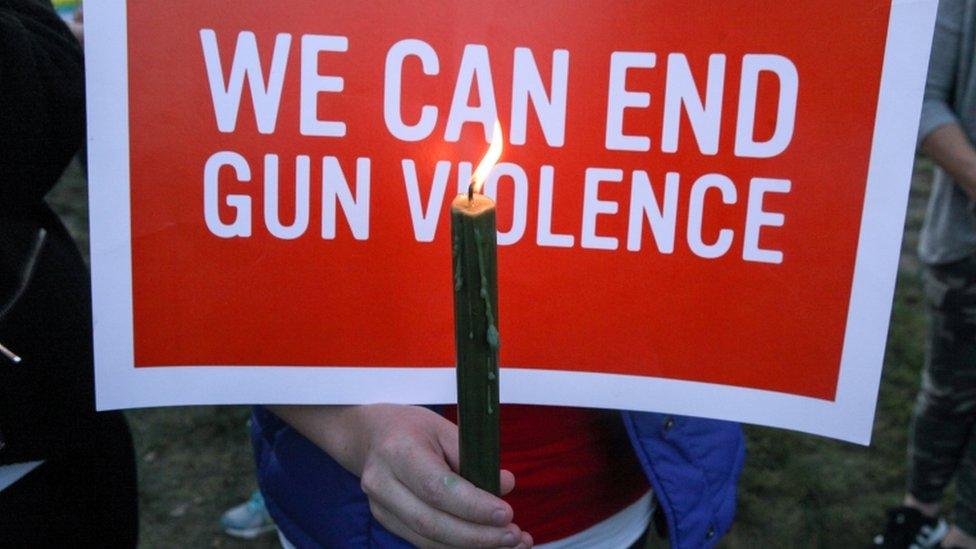 Mourners hold signs during a solidarity vigil in memory of victims of Las Vegas Route 91 Harvest music festival mass killing, in Newtown, Connecticut