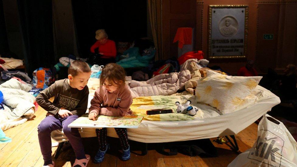 Refugee children reading a book