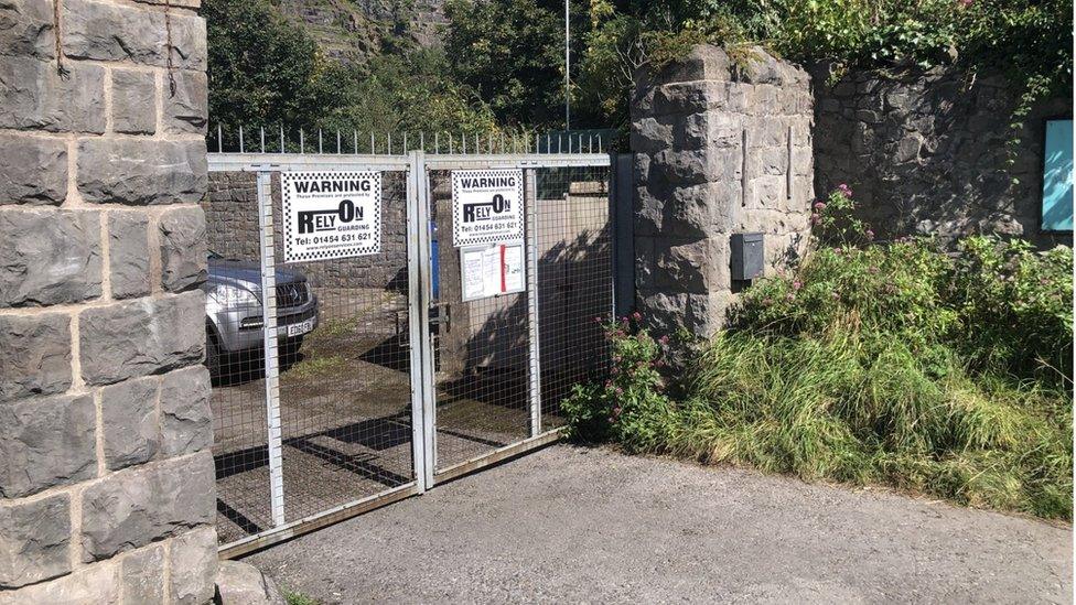 Locked gates with spikes and warning signs