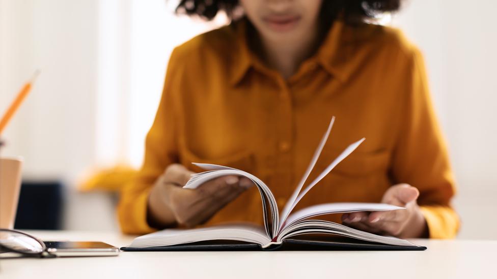 A teacher reads through a book