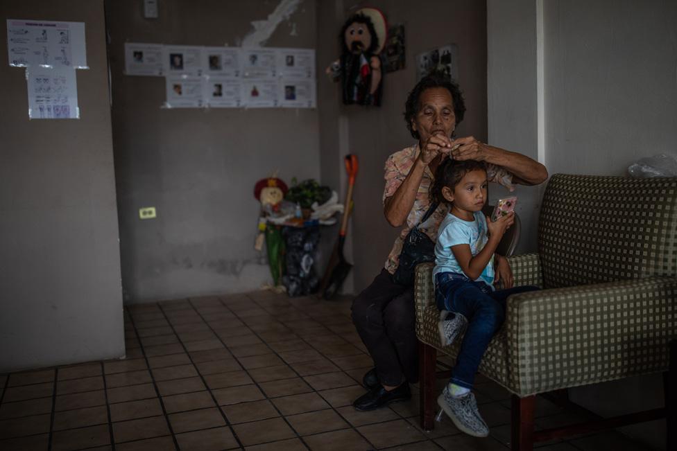 Lucia Guadalupe brushes the hair of her granddaughter