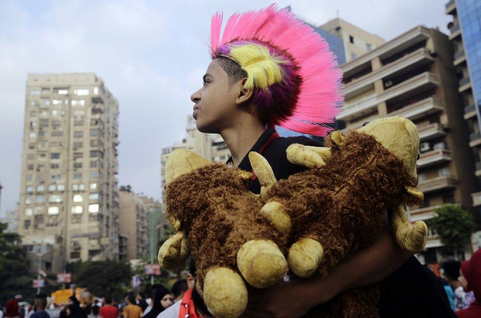 A boys sells stuffed animals after the dawn Eid al-Adha prayers at Moustafa Mahmoud Square in Cairo, Egypt - Monday 12 September 2016