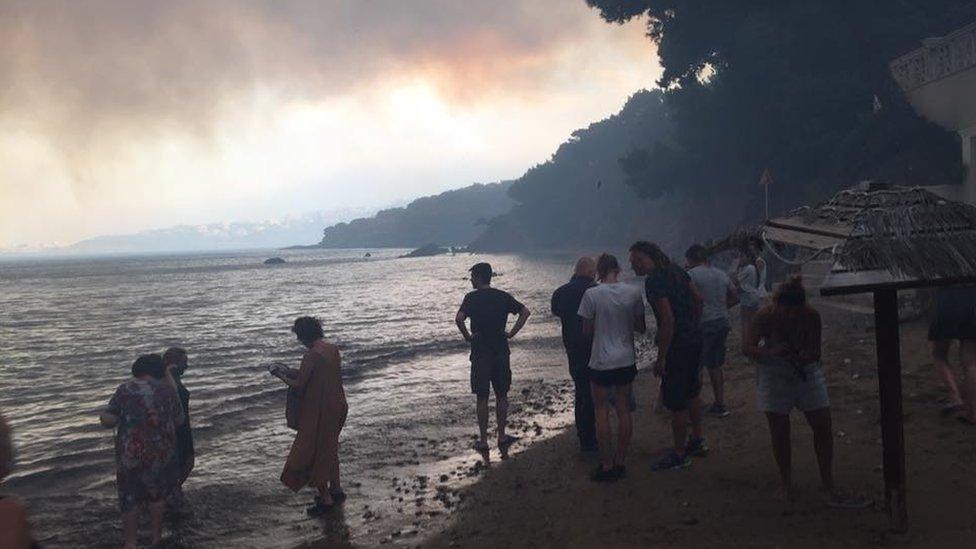 People on the coast in Greece to escape the fire